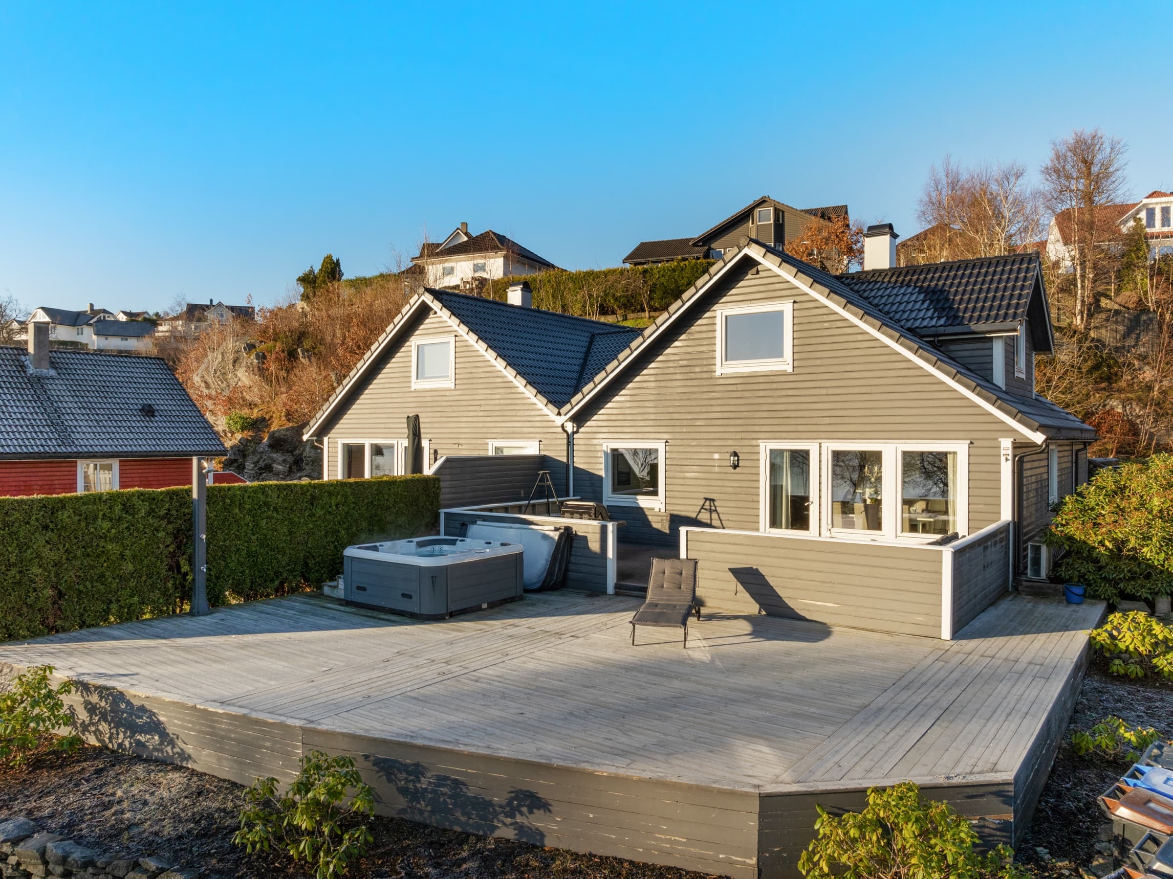 The same house after editing: balanced exposure, natural landscape color and a clean blue sky