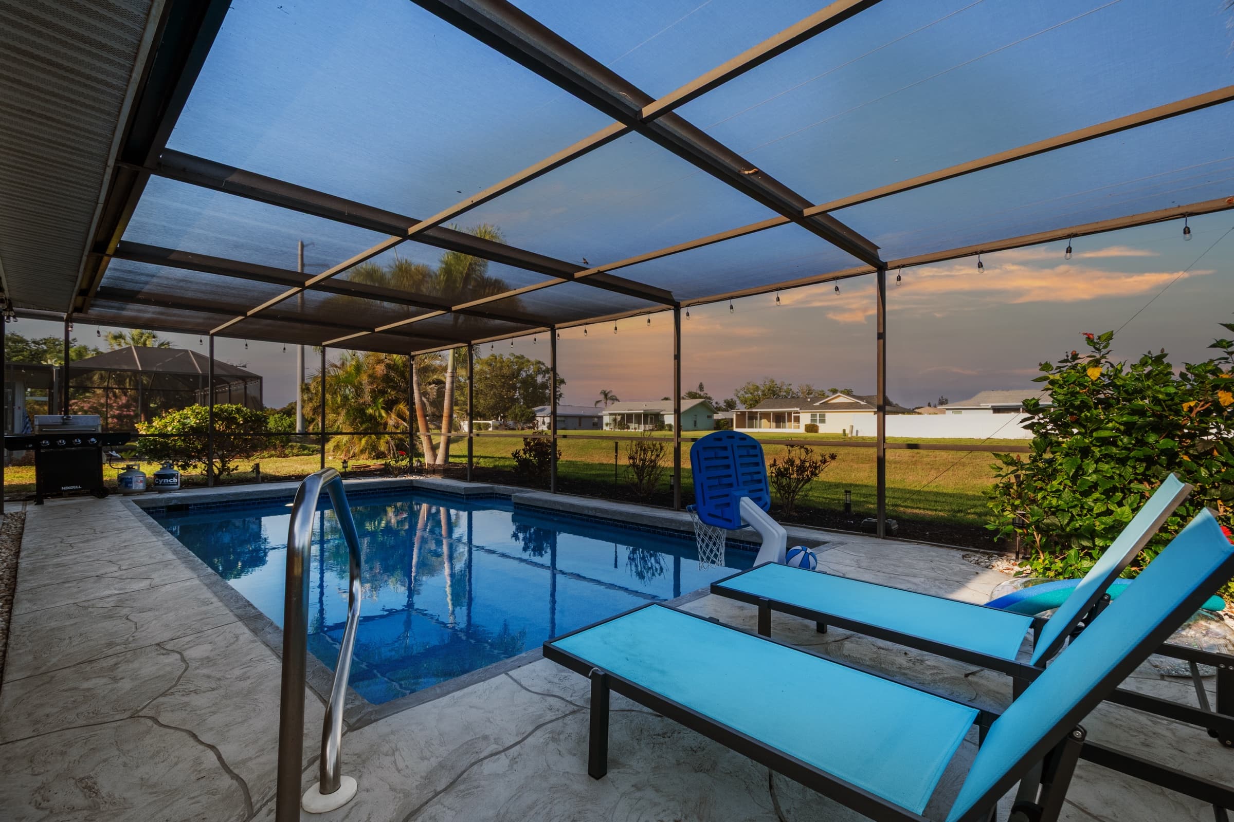 The same pool enclosure after editing: straight lines, deeper pool color and a soft sky with warm clouds
