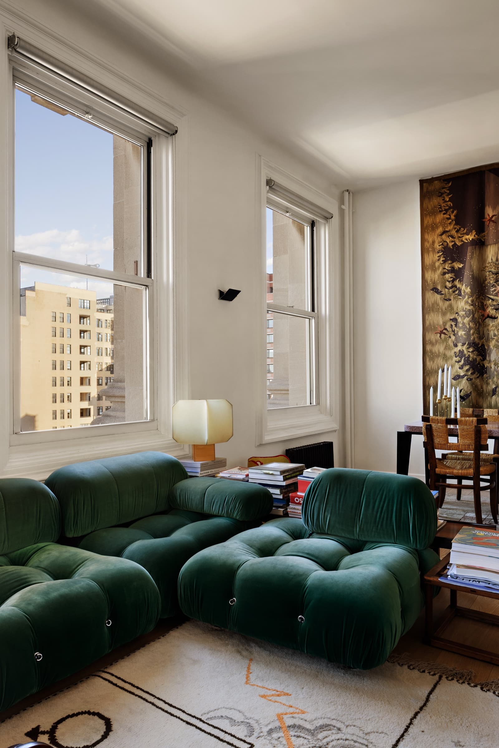 The same living room after a design-led edit: rich green velvet, tapestry texture and natural window detail preserved