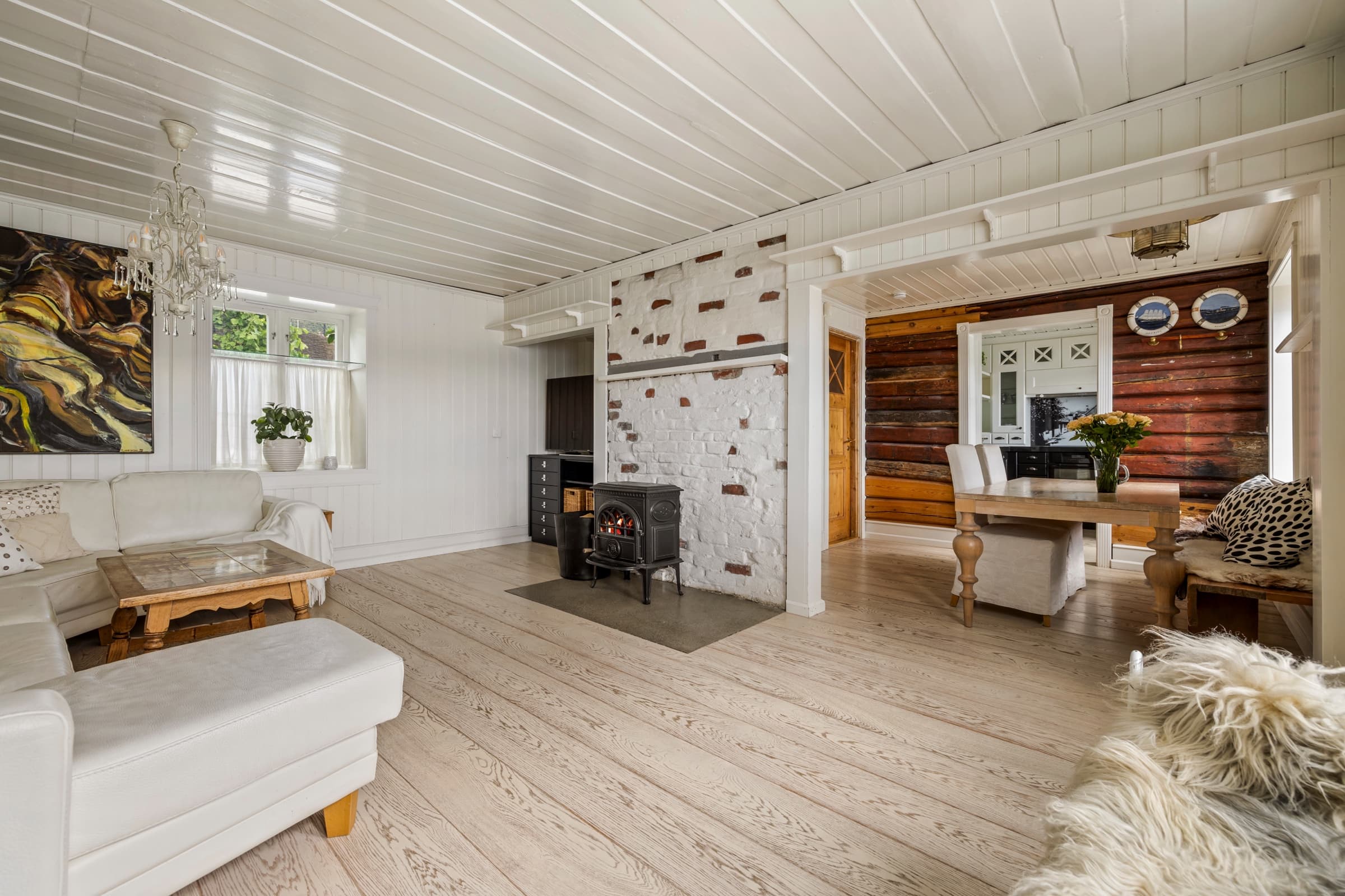 The same living room after editing: bright, even light and clean whites with natural wood and brick tones