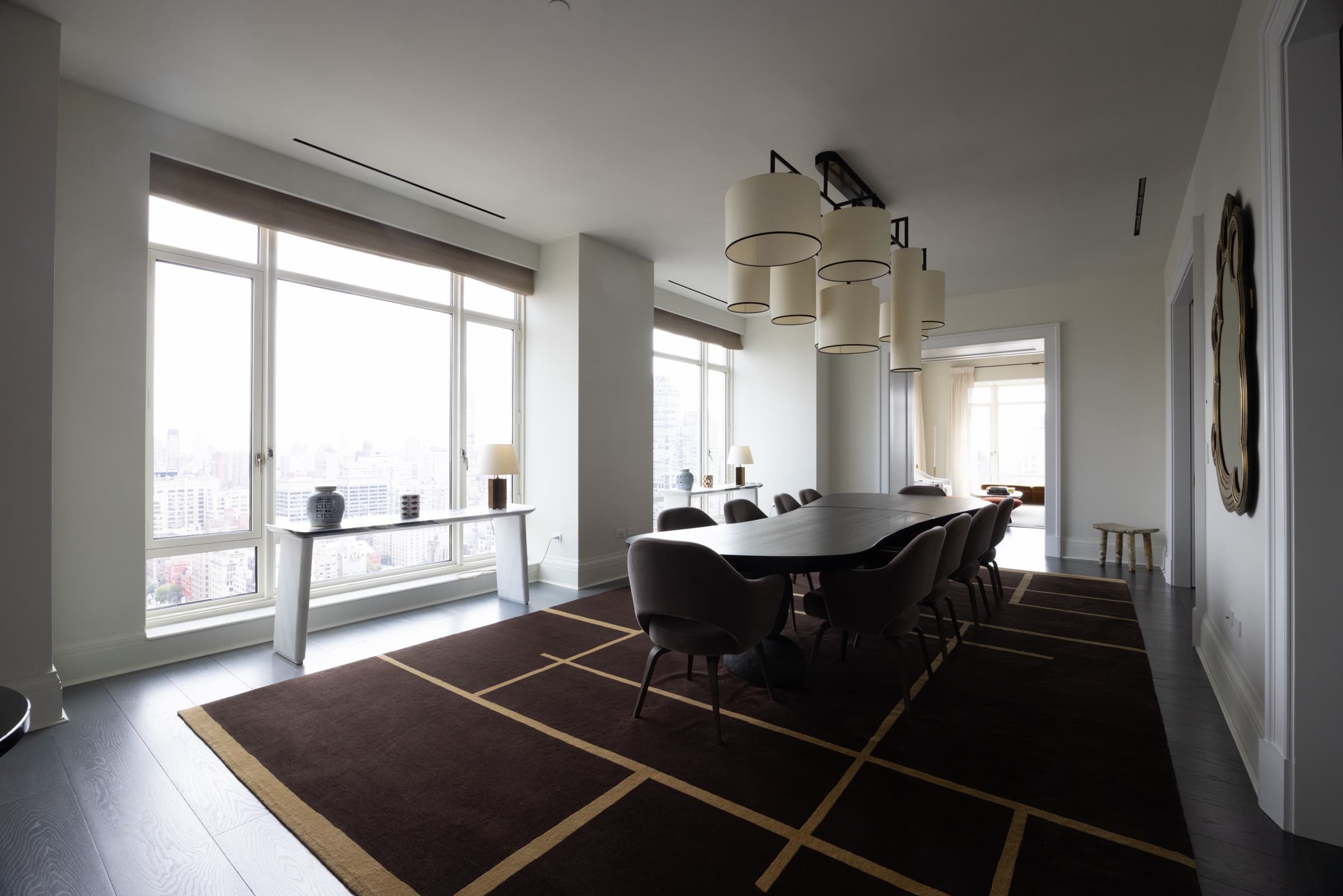 High-rise dining room with a long table and tall windows, original unedited photo with dim light and washed-out windows