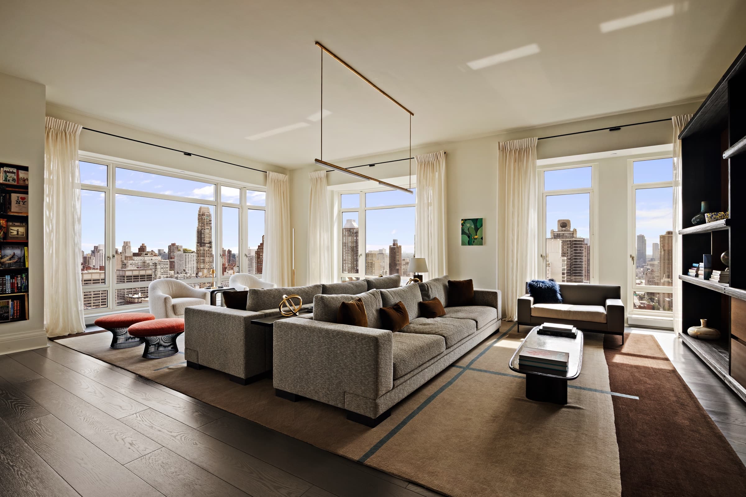 The same living room after a design-led edit: controlled contrast, preserved furniture and material color, and a clear city view
