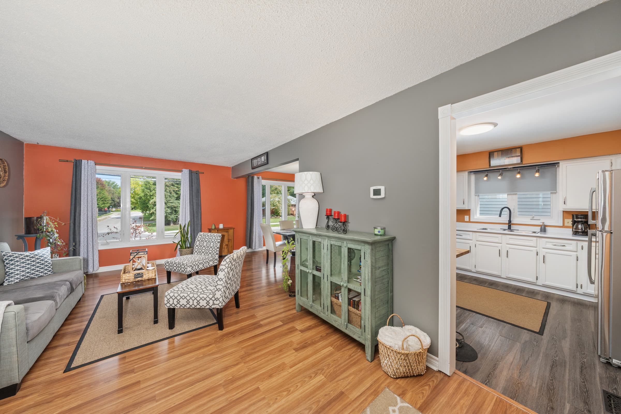 The same living room and kitchen after flambient editing, with balanced daylight, natural color and controlled window detail