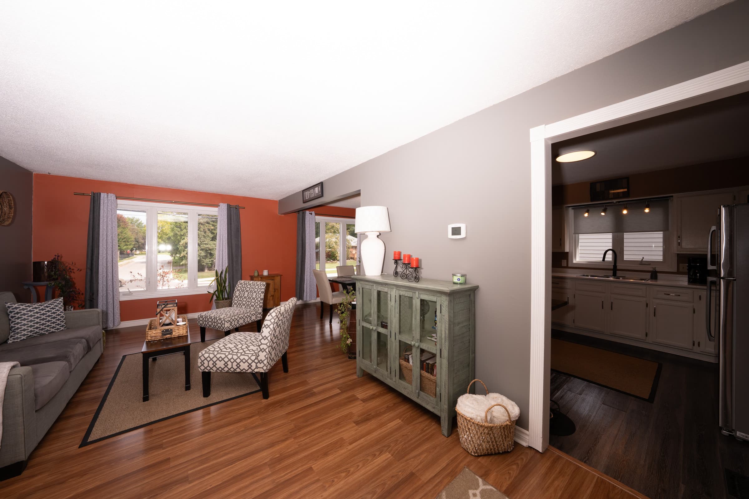 Living room opening into a kitchen, source frame with darker interior areas and mixed light