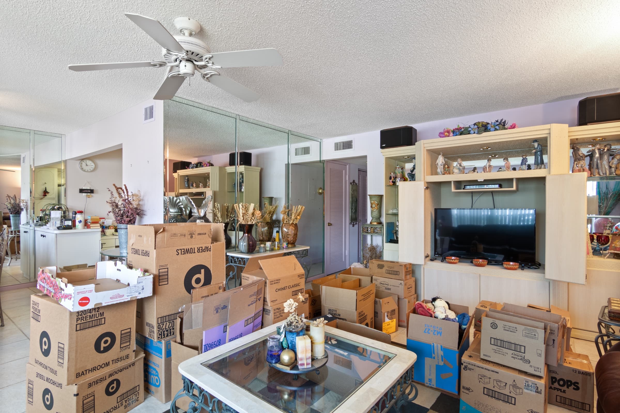 Living room crowded with moving boxes, furniture and personal items, original photo
